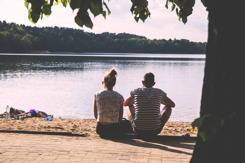 Couple sitting on the beach - free stock photo