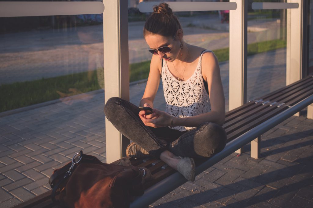 Girl sitting at tram stop - free stock photo