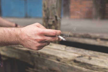 Cigarette in a male hand - free stock photo