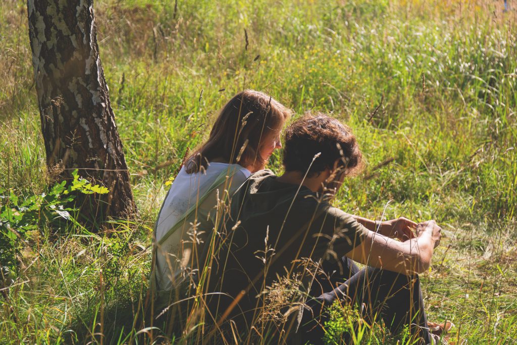 Couple sitting in the meadow - free stock photo