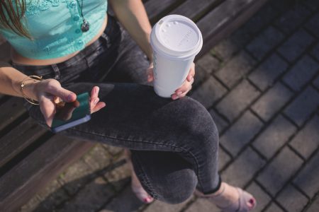 Girl holding phone and coffee - free stock photo