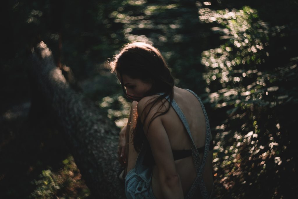 Girl sitting on a tree trunk - free stock photo