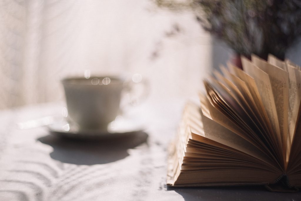 Open book and a cup of tea - free stock photo