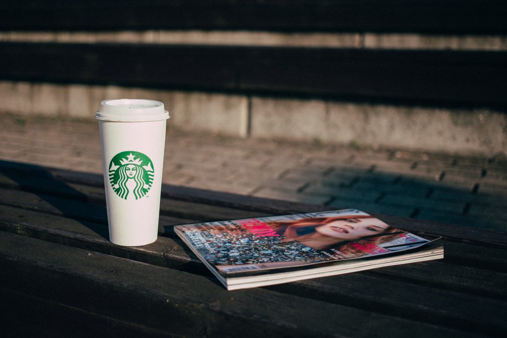 Coffee and a magazine on a bench - free stock photo