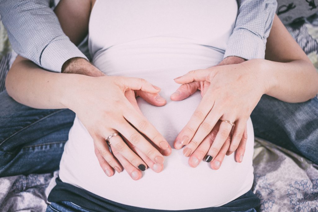 Heart shape on a pregnant belly - free stock photo