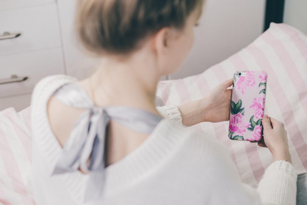 A girl holding a phone in a fancy case - free stock photo