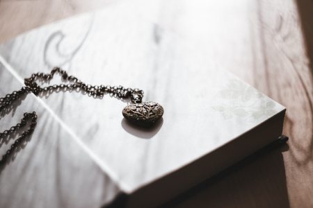 Heart necklace on an open book - free stock photo