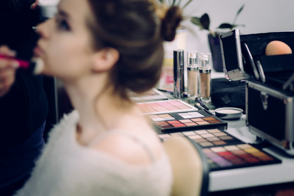 A model and a makeup artist at work - free stock photo