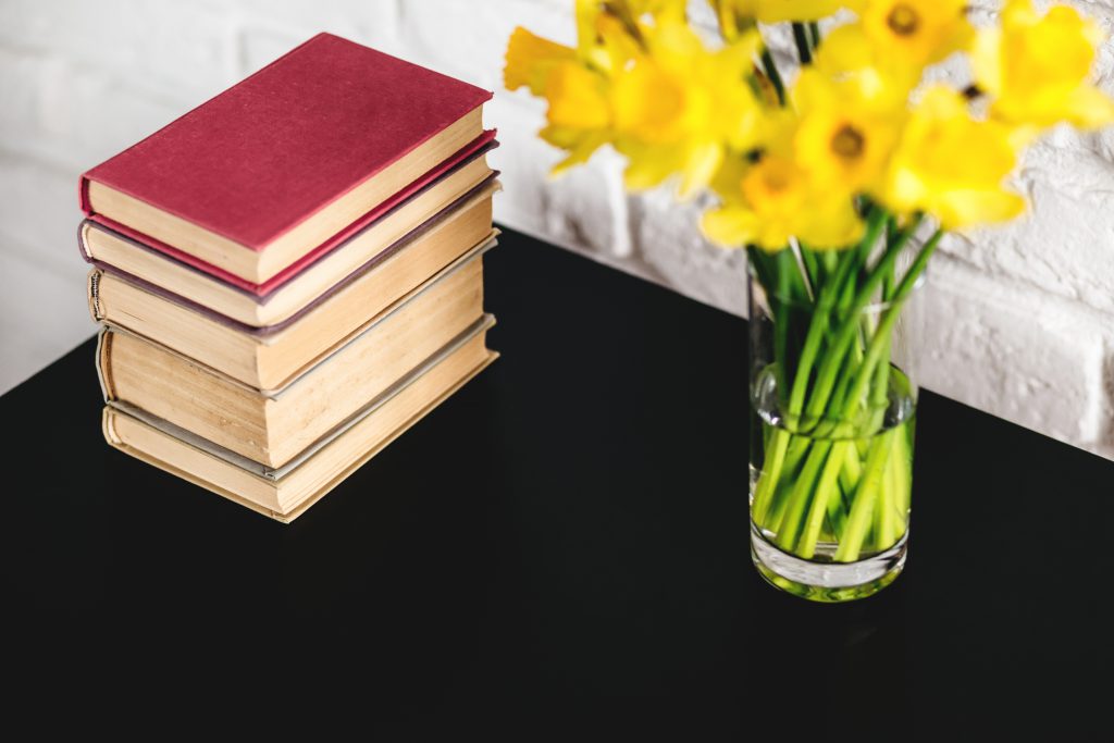 Spring daffodils and books on black table - free stock photo