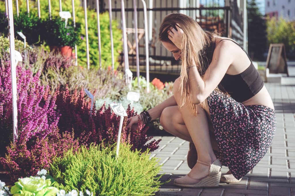 A girl looking at flowers - free stock photo