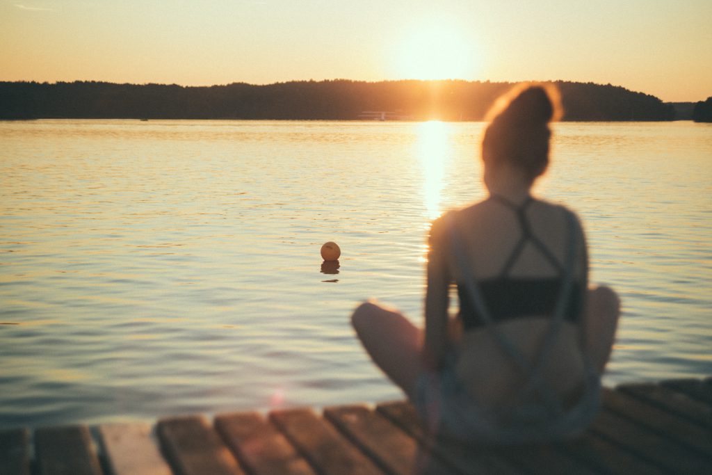 A girl sitting on a pier blurred - free stock photo