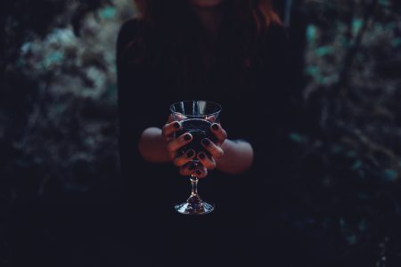 A witch holding a glass of wine - free stock photo
