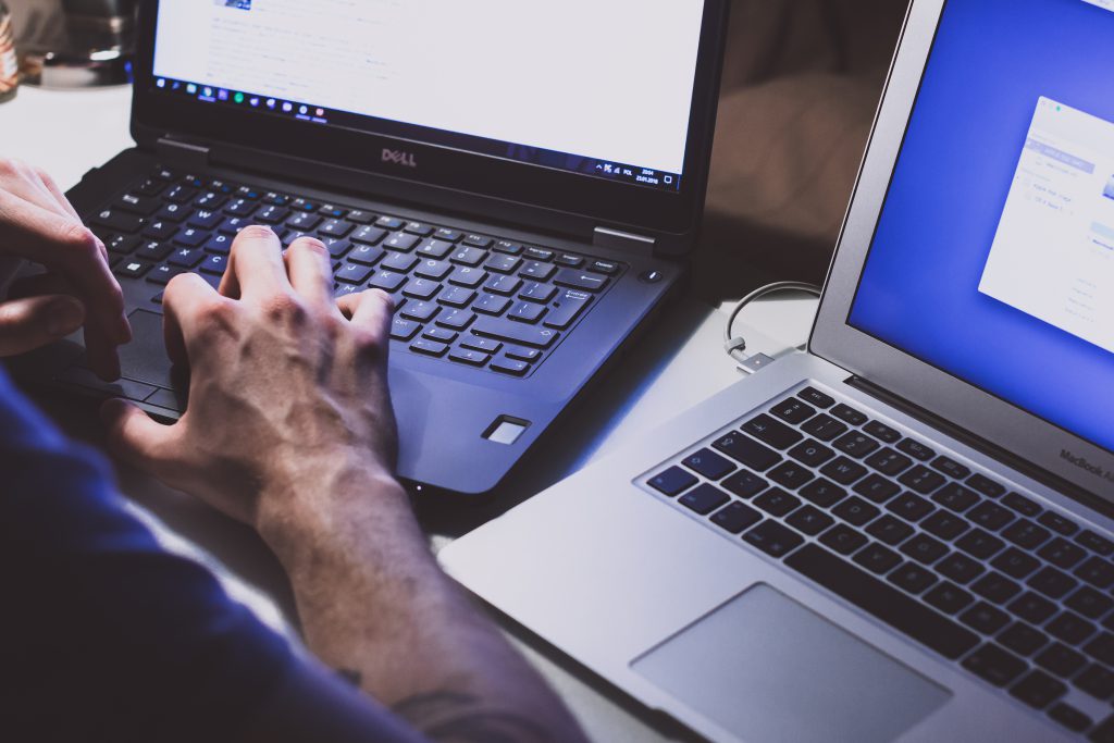 Man working on two notebooks - free stock photo