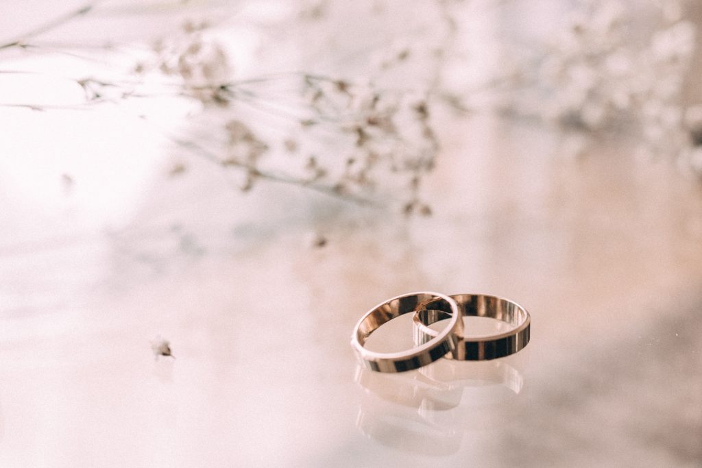 Wedding rings on a glass table - free stock photo