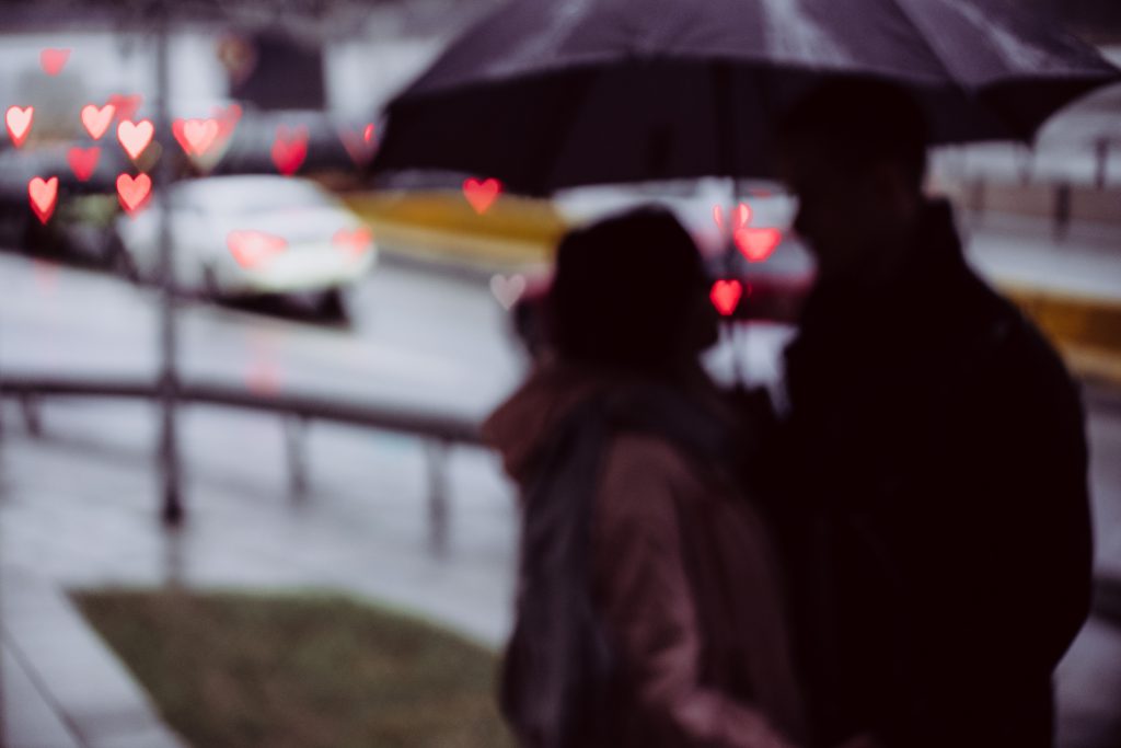 Couple silhouettes and traffic lights heart shaped bokeh - free stock photo