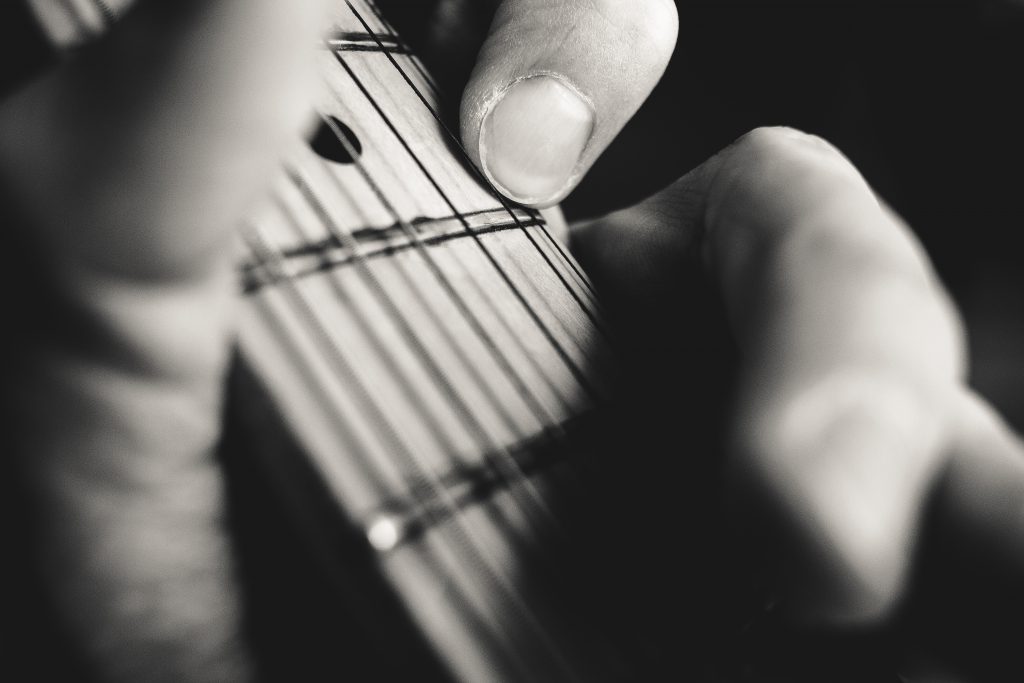 Guitarist hand playing guitar closeup - free stock photo