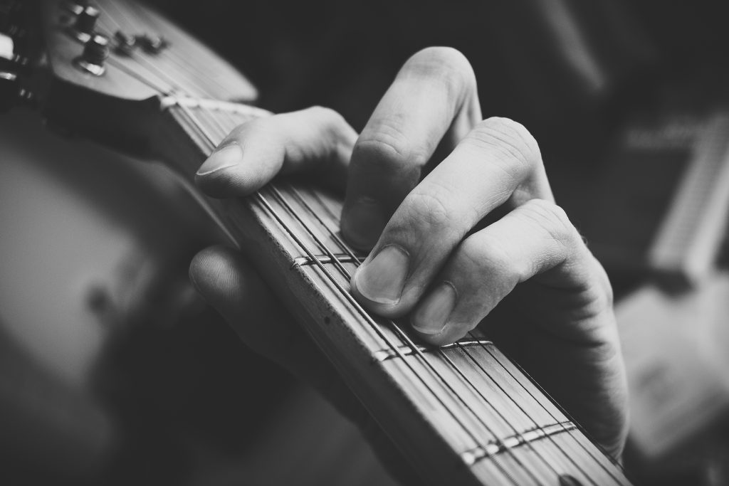 Guitarist hand playing guitar in black and white 2 - free stock photo