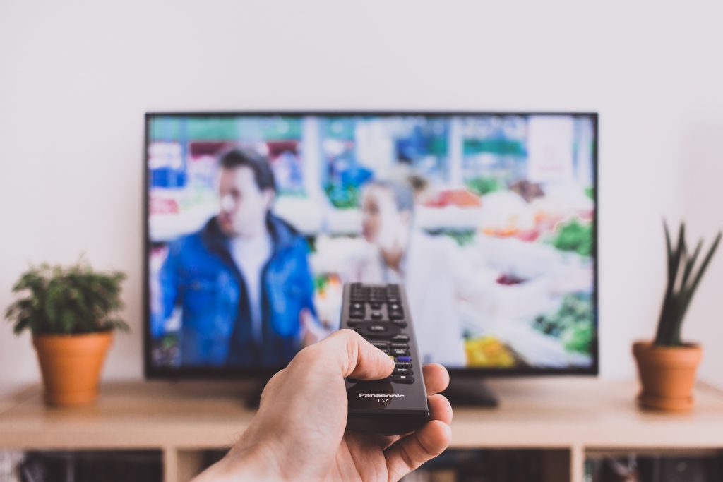 Remote control pointed at a TV screen - free stock photo