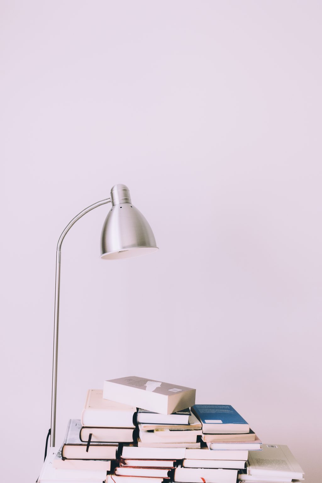 Metal desk lamp and books pile - free stock photo