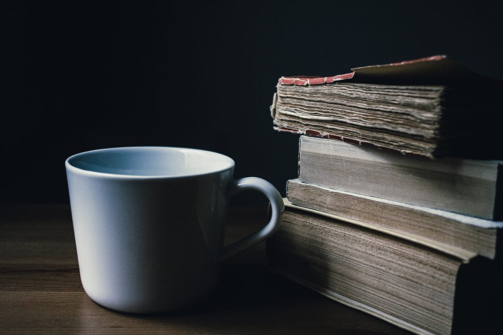 Tea mug and a pile of books - free stock photo