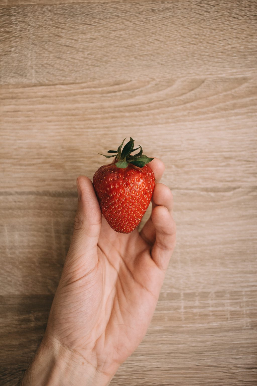 Strawberry in a male hand - free stock photo
