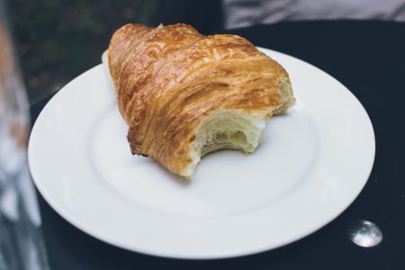 Bitten butter croissant on a plate - free stock photo