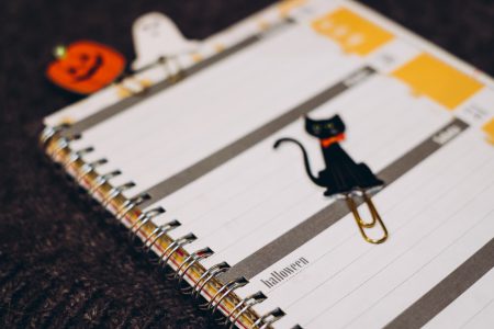 Black cat, a pumpkin and a ghost paperclips in a calendar - free stock photo