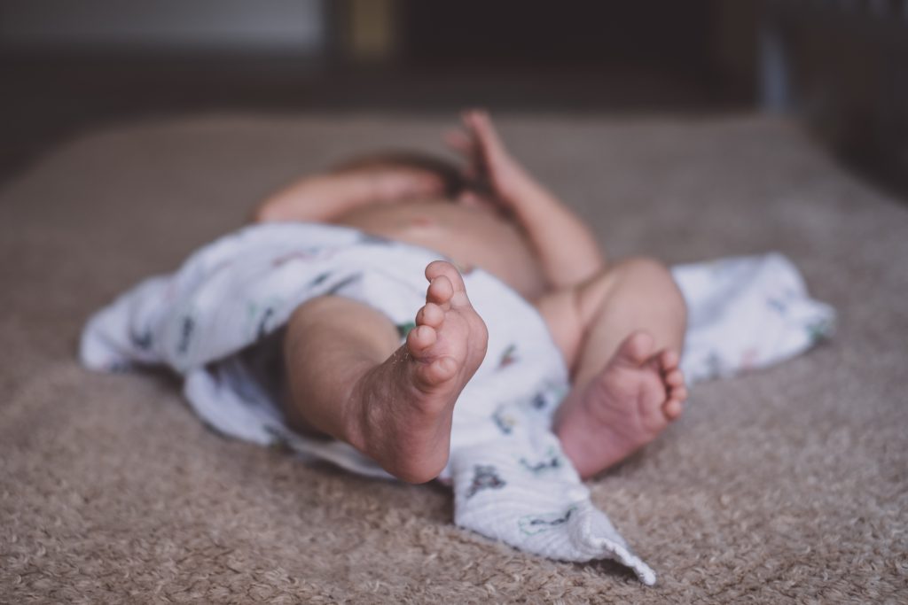 Newborn baby lying down on the mattress - free stock photo