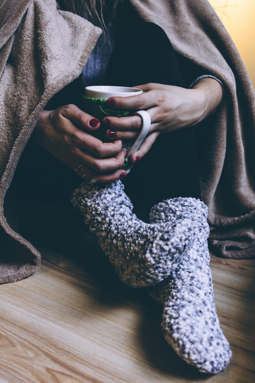 A female in warm socks holding a mug - free stock photo