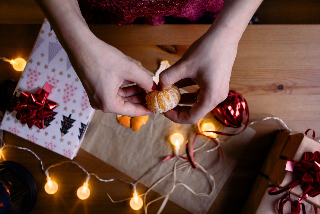 A female peeling a mandarin in a festive setting 2 - free stock photo