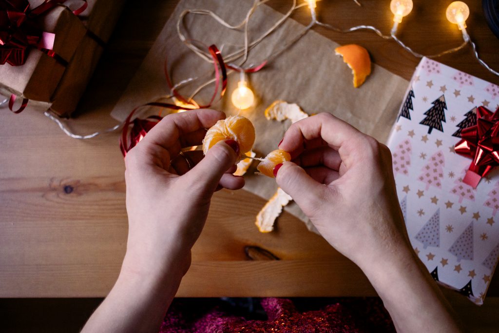 A female peeling a mandarin in a festive setting 3 - free stock photo