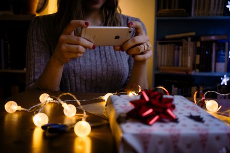 A female taking picture of a christmas gift - free stock photo