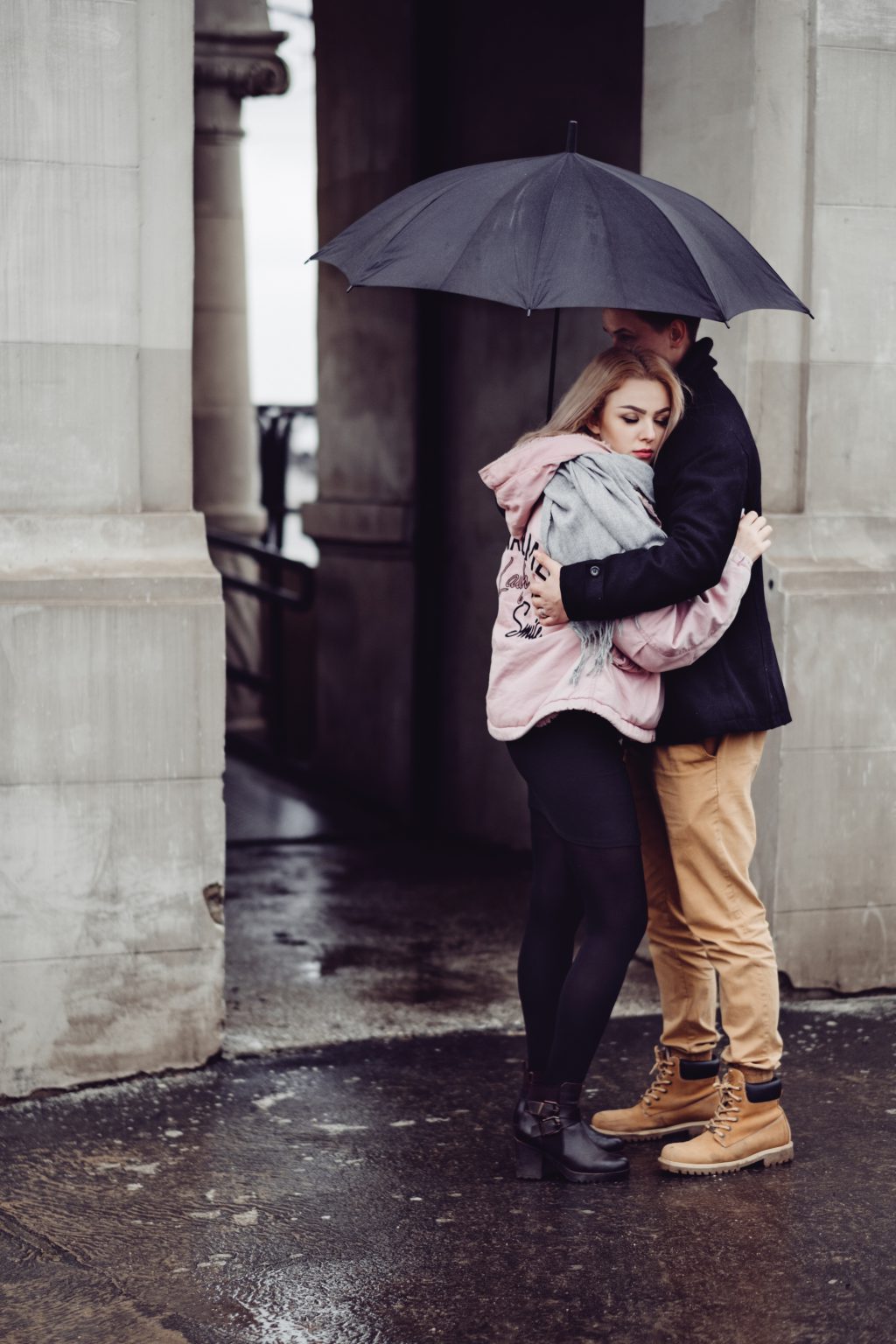 Couple hugging under an umbrella - free stock photo