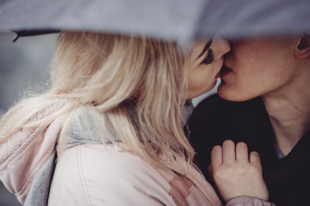 Couple kissing under an umbrella - free stock photo