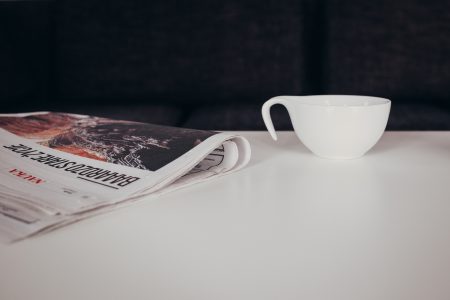 Cup of coffee and a newspaper on the table - free stock photo