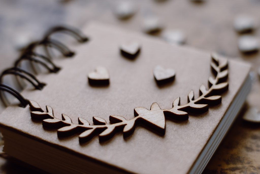 Wooden heart decorations on a notebook - free stock photo