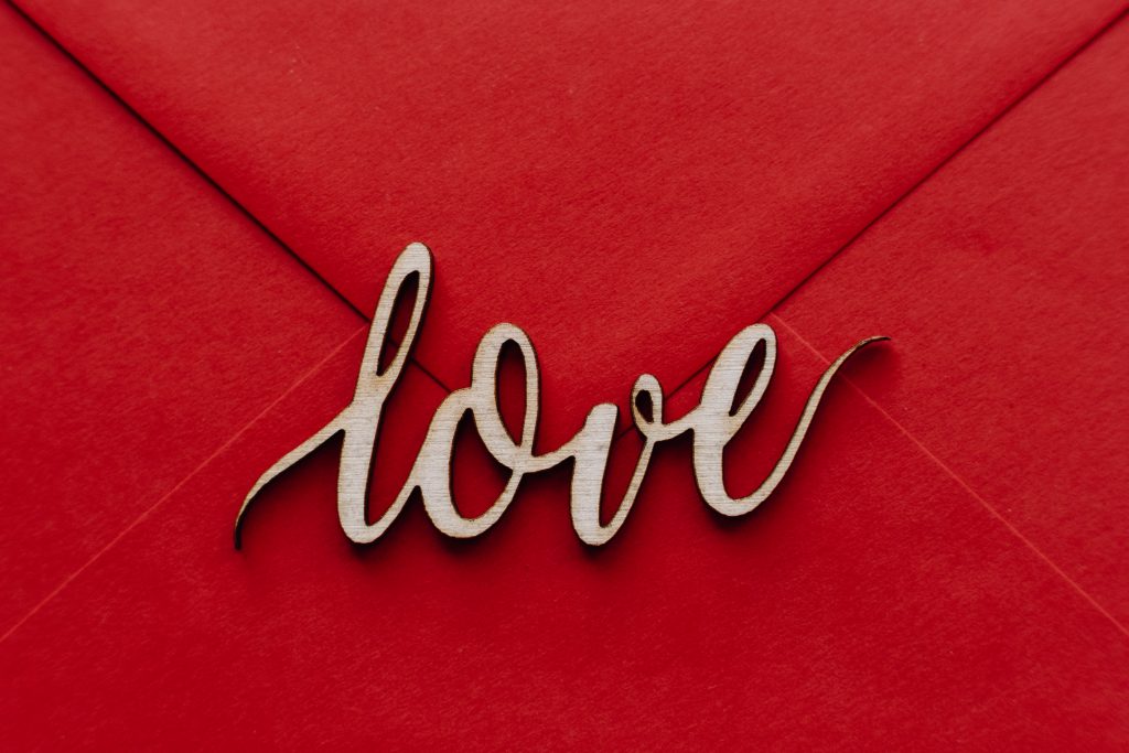 Wooden word love on a red envelope - free stock photo