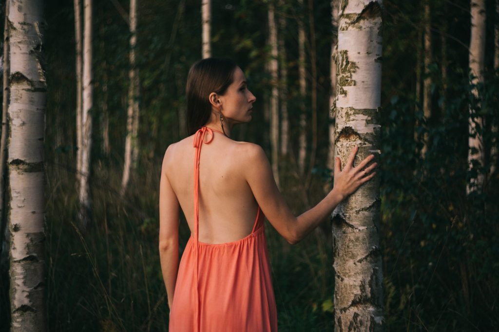 A girl in a backless dress in the woods - free stock photo