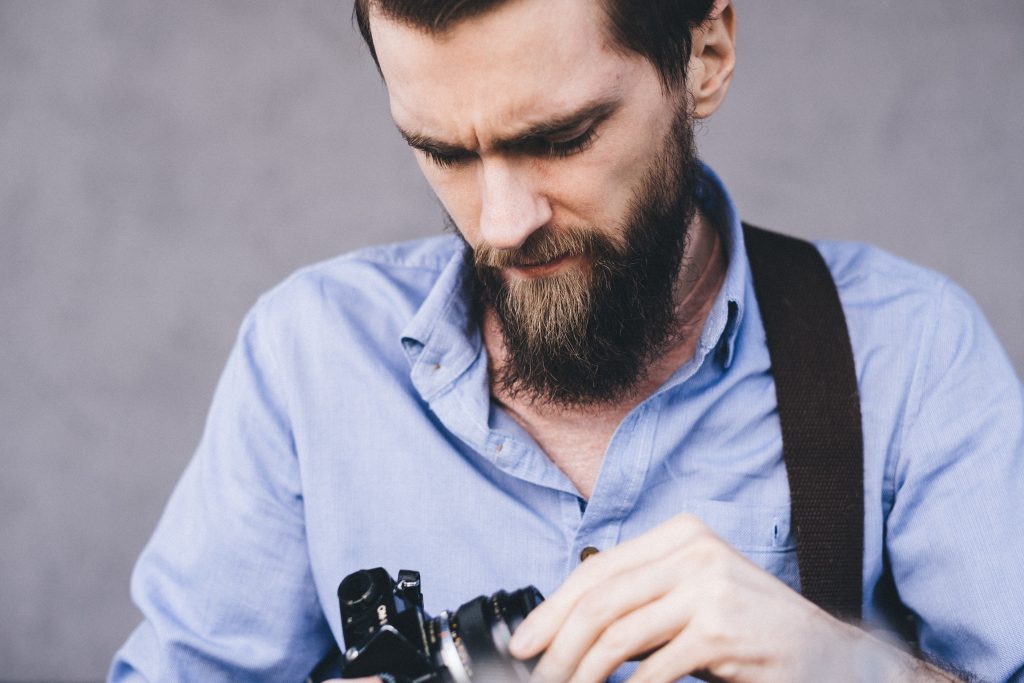 A man holding an analog camera - free stock photo