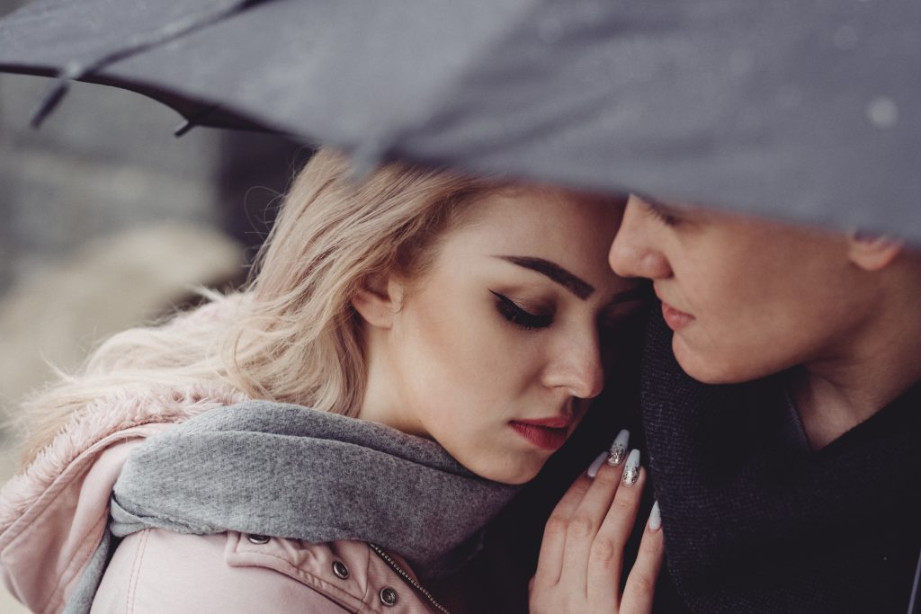 A couple hugging under an umbrella closeup - free stock photo