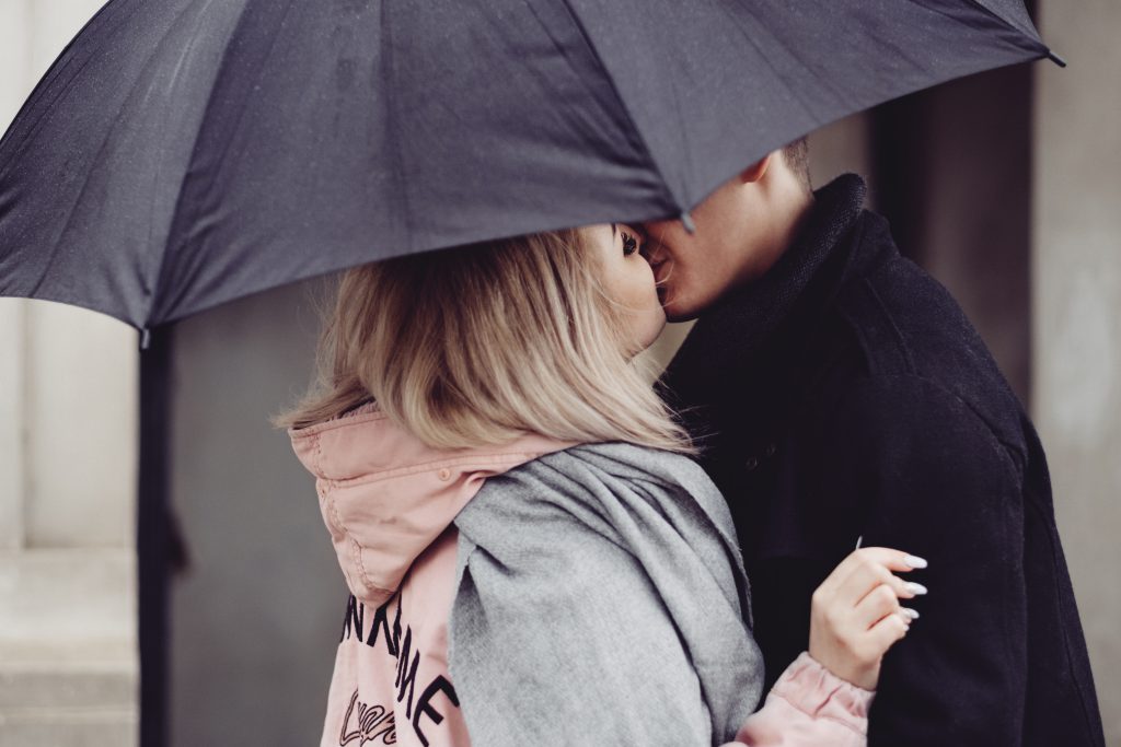 A couple kissing under an umbrella 2 - free stock photo