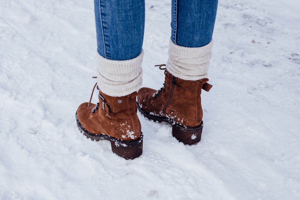Female feet standing on a snow-covered pavement 2 - free stock photo