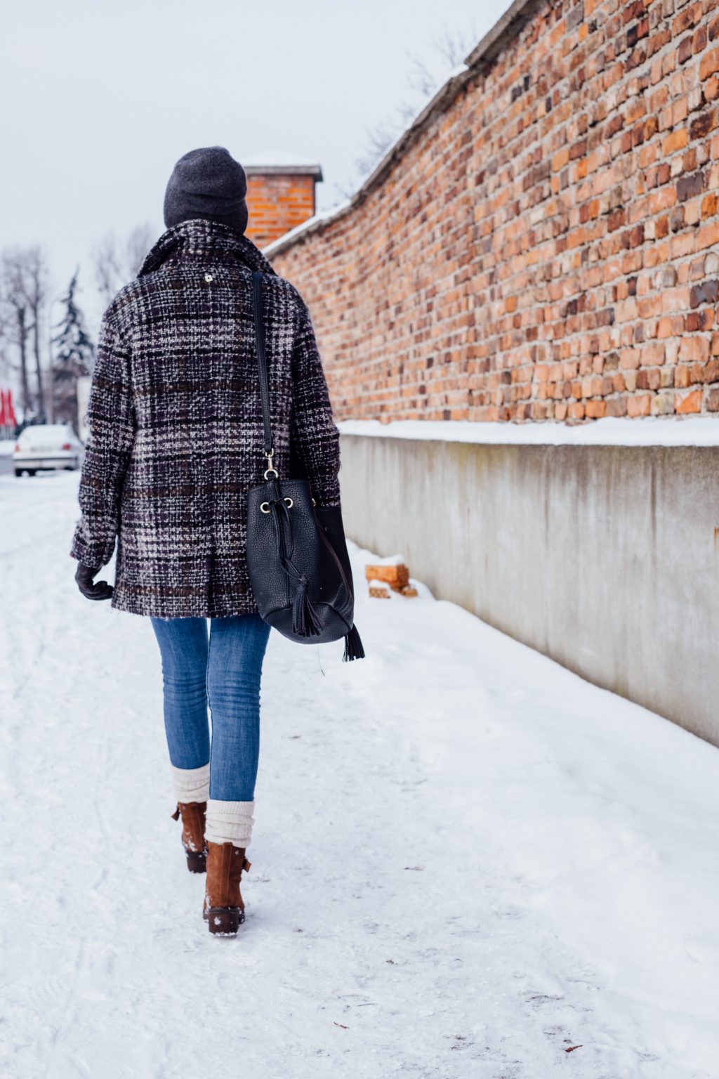 A female walking on a snow-covered pavement - free stock photo