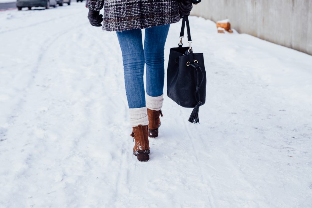 A female walking on a snow-covered pavement 3 - free stock photo