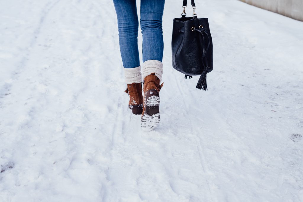 A female walking on a snow-covered pavement 4 - free stock photo