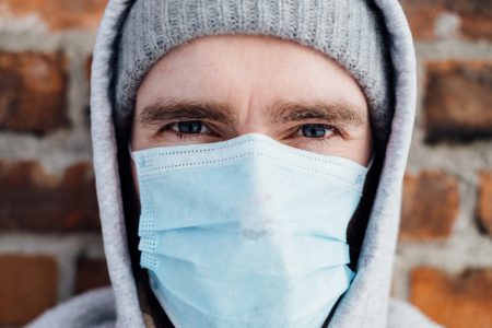 A male wearing a protective face mask closeup - free stock photo