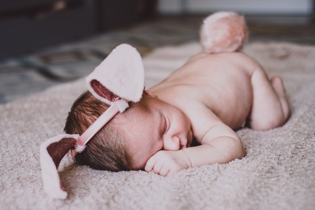 Newborn baby with bunny ears and a tail - free stock photo