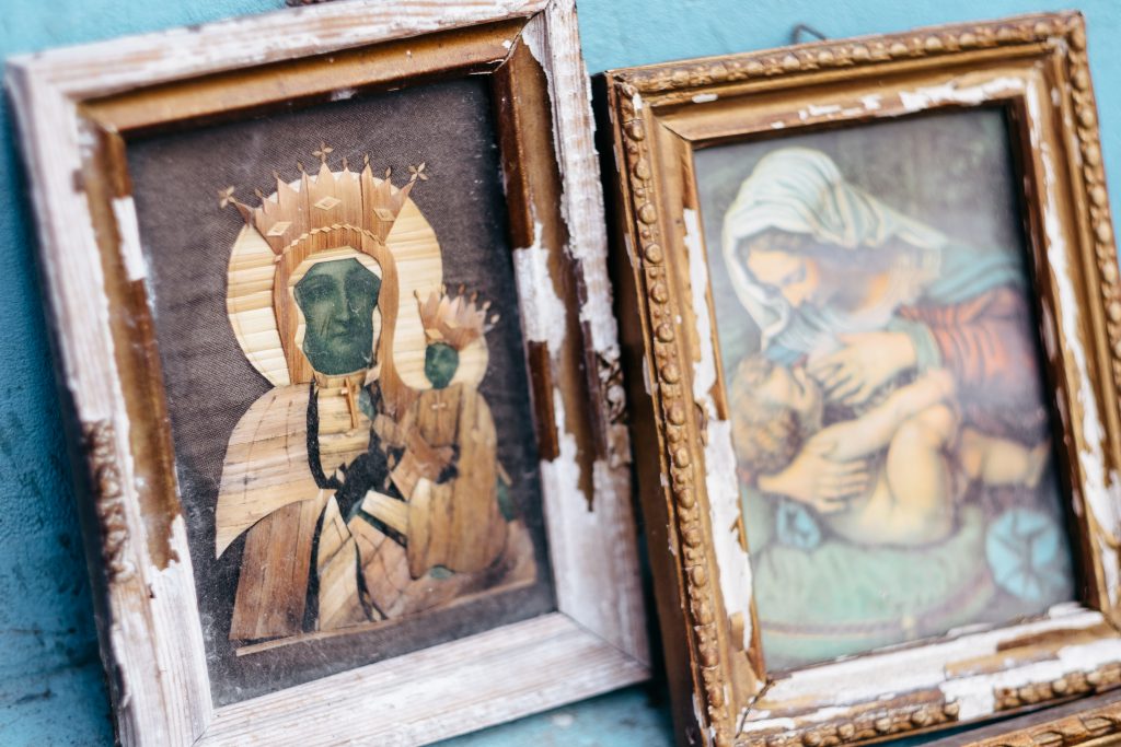 Distressed catholic holy pictures placed outside a poor neighbourhood closeup - free stock photo