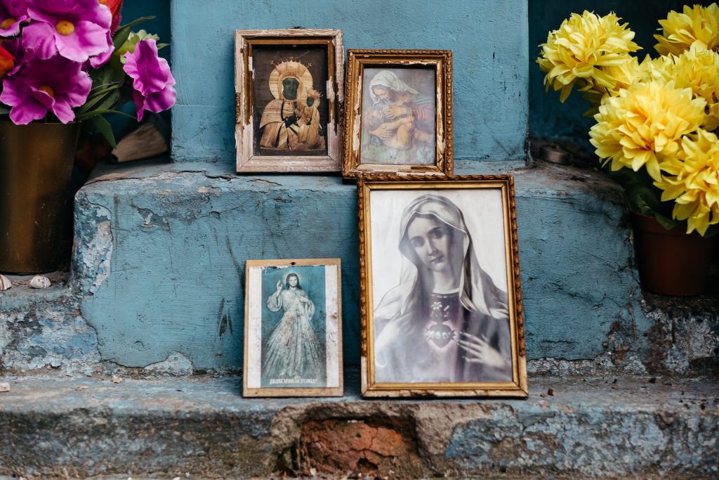 Distressed catholic holy pictures placed outside a poor neighbourhood - free stock photo