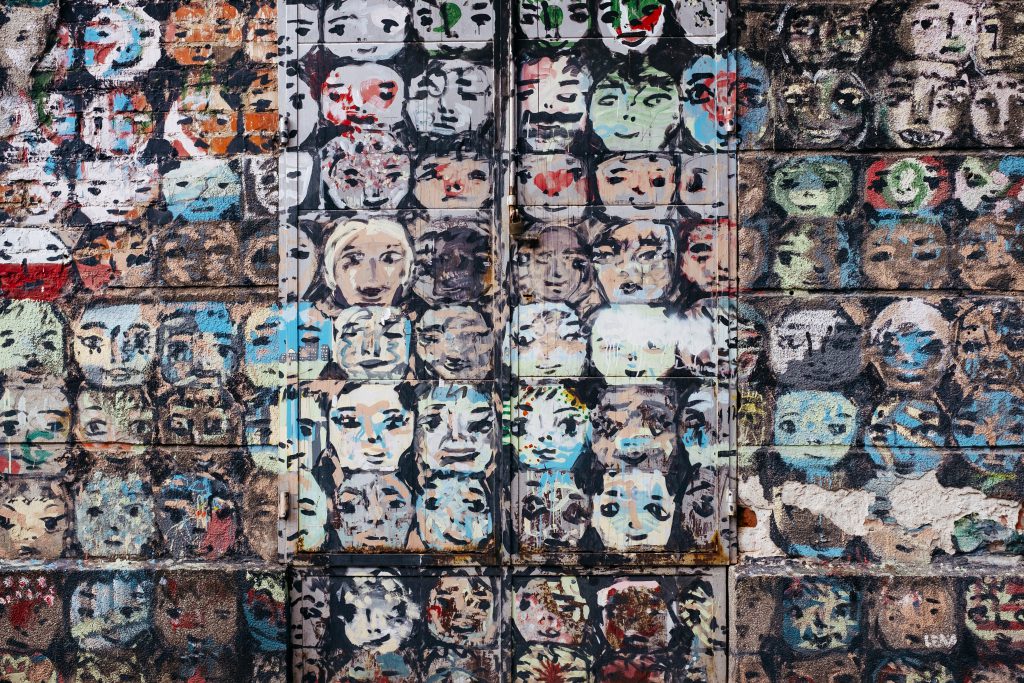 Graffiti of many cartoonlike faces on a building - free stock photo